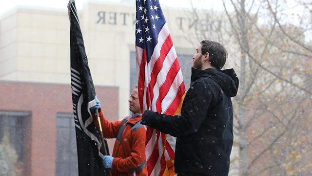 Two student veterans raising an American flag